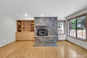River rock wood burning FP with insert and built-in electric fan. Built-in cabinets in family room.