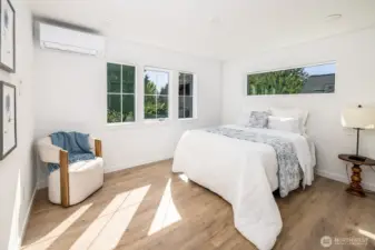 Top floor primary suite with green views, natural light and thoughtful design elements including nightstand light switches and TV mount station midway up wall for ease of mounting without wire and cable showing.