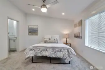 Primary Suite with vaulted ceilings, opens to double sink ensuite bathroom. Ceiling fan and walk-in closet.