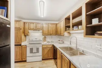 Updated countertops, tile backsplash, sink and lighting in the kitchen