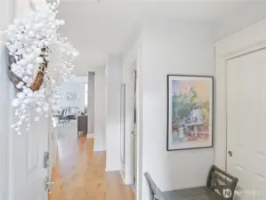 Staged view of Unit Entry with generous sized entry closet. Built-ins line the hall and extra closet space.   All closets have built-ins.