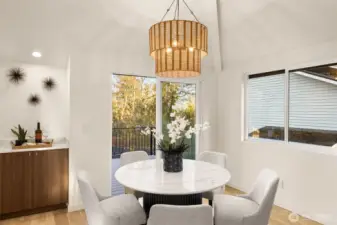 The dining area is flooded with an abundance of natural light from the connected deck