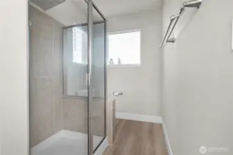 Enjoy a spacious, tiled shower with glass doors that fill the space with natural light.