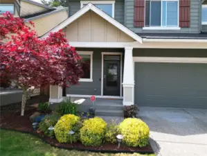 The front entry is highlighted by graceful columns and lush greenery creating a warm, inviting entrance to the home.