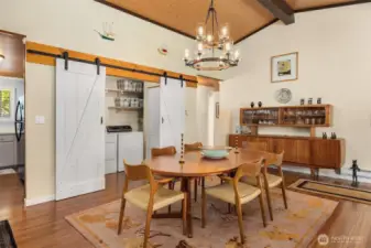 Dining room showcasing barn door entrance to laundry area.
