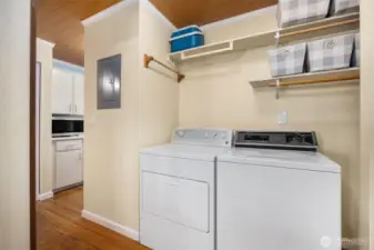 Kitchen seamlessly flowing into in-unit laundry area, also providing additional storage.