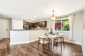 The open kitchen features a breakfast bar. Fresh updates throughout, including new trim and vinyl plank flooring.