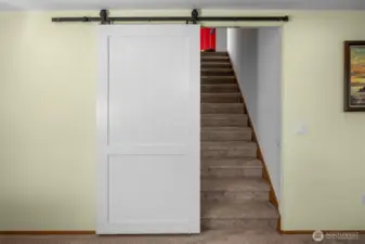 Modern barn door nicely separates the spaces.