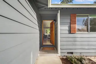 Front entry leading to spacious living room with wood stove.