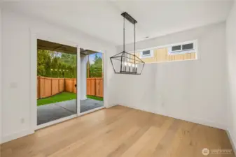 This dining area is filled with natural light from the wide sliding glass doors and high horizontal window, creating a warm and welcoming space. The modern chandelier anchors the room and opens to the covered patio for easy indoor-outdoor dining. It’s an ideal setup for everyday meals, hosting friends, or simply enjoying the private backyard setting.    These photos are from lot 3 at Gooden Hollow, the actual home for sale. However, other homes may vary, so all photos, renderings, site maps, and floorplans are for visualization purposes only. Plans, colors, building orientation, finishes, home outlook, and other details can and WILL vary.