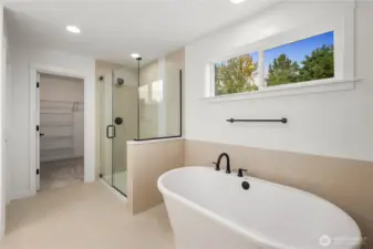 A luxurious walk-in shower with frameless glass and tile surround sits beside a sleek freestanding tub with high windows for no loss of light with added privacy. This layout offers both a spa-like retreat and functional everyday comfort in a beautifully curated design.    These photos are from lot 3 at Gooden Hollow, the actual home for sale. However, other homes may vary, so all photos, renderings, site maps, and floorplans are for visualization purposes only. Plans, colors, building orientation, finishes, home outlook, and other details can and WILL vary.