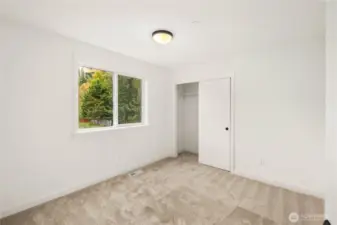 This comfortable secondary bedroom features a wide window overlooking mature evergreens for added privacy and natural serenity. Its neutral finishes and generous layout make it an easy canvas for a variety of uses, from sleeping space to study or flex room.    These photos are from lot 3 at Gooden Hollow, the actual home for sale. However, other homes may vary, so all photos, renderings, site maps, and floorplans are for visualization purposes only. Plans, colors, building orientation, finishes, home outlook, and other details can and WILL vary.