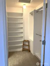 Master closet has shelves, hanging racks, and a built-in hamper