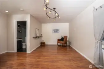 The shiplap accent wall adds a nice custom touch to the family/great room. The half bath - utility room combo is through the doorway on the left.