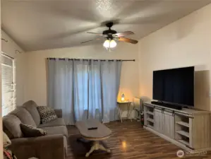 Rec room off the dining room, offering vaulted ceilings and a fan.