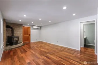Lower level living room with stunning flooring, real wood stove, access to garage and Chalet covered back patio