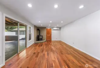 Lower level living room with stunning flooring, real wood stove, access to garage and Chalet covered back patio