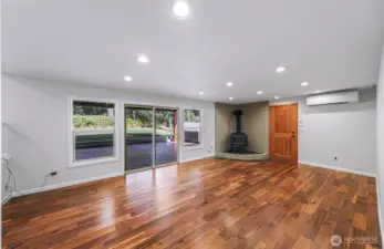 Lower level living room with stunning flooring, real wood stove, access to garage and Chalet covered back patio