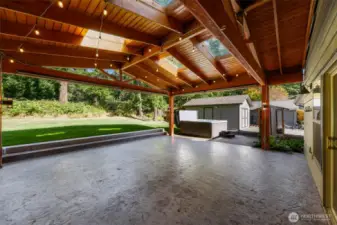 GRAND chalet style covered patio with stained concrete, skylights and powered lights and plugs next to the large hot tub