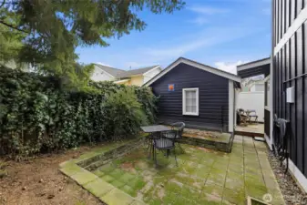 A view of the private patio behind the home with the standalone room.