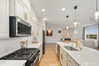 From the kitchen, the home’s open-concept layout comes into full view, connecting the cooking space with the living room and fireplace feature wall. This vantage point highlights how easily the main living areas work together for daily life and entertaining.