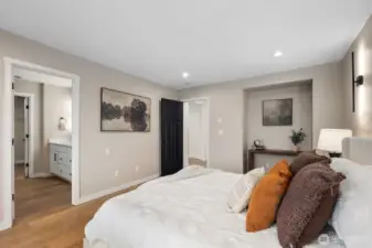 From this angle, the primary suite highlights its airy proportions and calming neutral palette. Large windows bring in natural light and neighborhood views, enhancing the serene atmosphere of this private bedroom retreat.