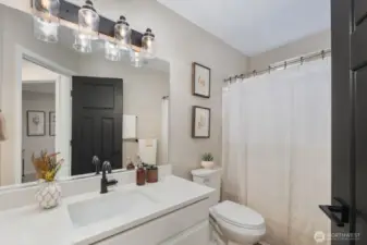 Bright full bathroom with wide vanity, modern lighting, and a clean shower and bath area. Thoughtfully designed for everyday functionality with a neutral palette that keeps the space light and welcoming.