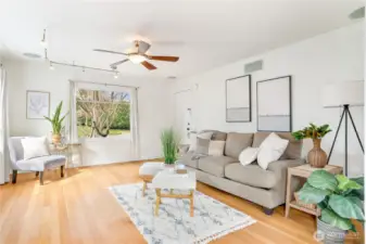 Large windows fill the living room with sunlight, creating a bright and inviting space.