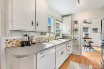 The kitchen offers good prep space, laminate flooring, and built-in shelving for added function.