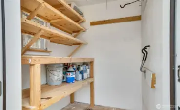 An exterior-access storage room with built-in shelving provides space for larger items like bikes, tools, or a lawnmower.