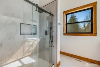 Primary Shower features tiled flooring and shower with cast iron pan.