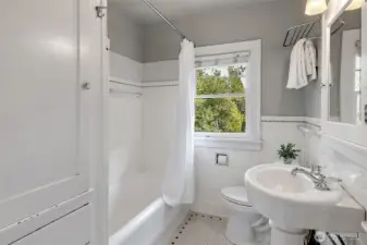 Upstairs full bath with bult in storage and original hex tile on the floor