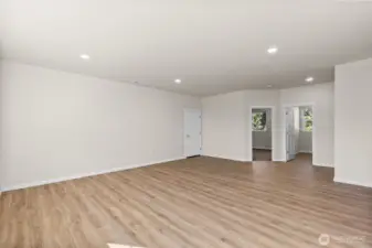 Another view of the great room, with primary bedroom and utility room also pictured.
