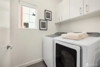 The laundry room has full size washer and dryer and custom cabinets for storage.