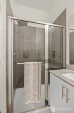 Primary shower with tile surround.