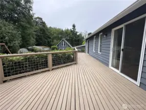 The outdoor deck overlooks the garden that has a firepit.  It has three sliding doors opening onto the deck from the living room, dining room and master bedroom