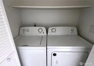 Washer and dryer in utility closet in hallway between dining room and master bedroom