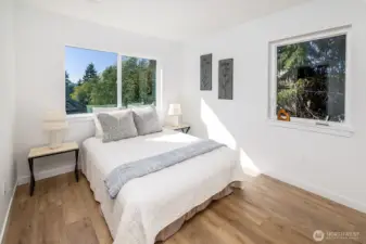 One of two additional bedrooms in addition to the primary ensuite.  Notice the canopy of trees out of each window.