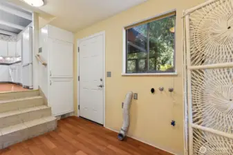 Utility room w/door leading to outside. Stairs on the left go to the kitchen.