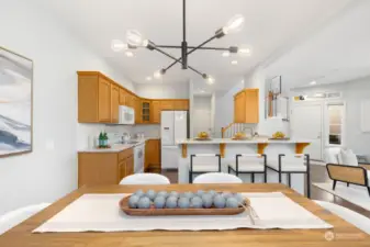 Bright and airy, this dining area features modern lighting and flows seamlessly into the kitchen for easy entertaining.