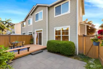 Enjoy outdoor dining or relaxing in this private backyard, complete with a spacious patio and cozy deck, perfect for summer gatherings.