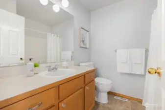 Crisp, clean, and functional, this well-appointed bathroom features modern fixtures and plenty of storage space.