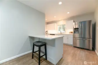 The main level features a full kitchen with a spacious eating and gathering area, complete with an eating bar, pantry, and a convenient laundry room—ideal for both everyday living and entertaining.