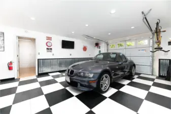 The showroom bay of the detached garage is a true highlight, featuring a game area and a stunning live-edge wood bar. Replace the mirror with a TV, and you’ve got your own year-round drive-in experience.