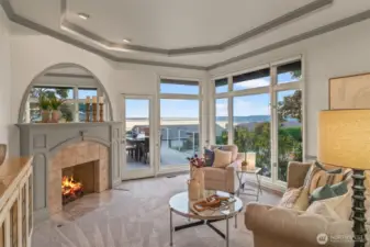 Formal living room with floor to ceiling windows and fireplace.