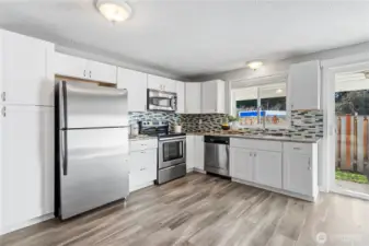 Enjoy the updated kitchen with granite countertops, sparkling stainless appliances, shaker cabinetry and full-height tiled backsplash.