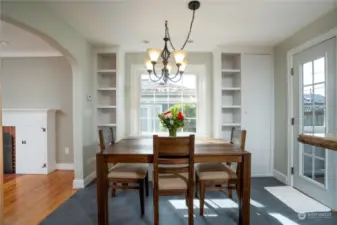 Coved archway, built-in shelving with bench seating in this dining room filled with abundant natural light.