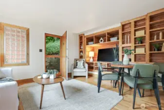 Main home living room with hardwood floors, woodstove, western views of the ship canal, and custom built in entertainment center.