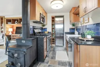 Remodeled kitchen features marble counter, tile floors, stainless appliance, live edge maple wood shelves,  gas range and cedar bump out for the refrigerator and shelving.
