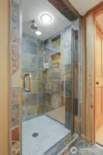 Lower level remodeled 3/4 tiled bathroom with heated stone floors and stone tiled shower.